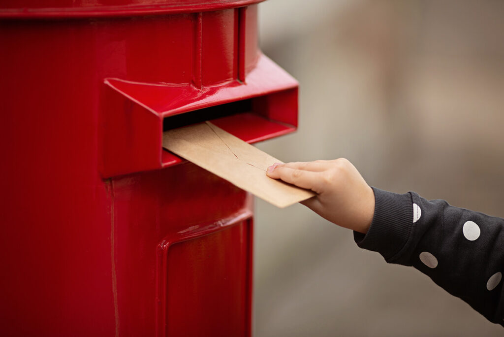 En pige der indsætter et postkort i en brevkasse. Denne artikel handler om hvad mailchimp er.